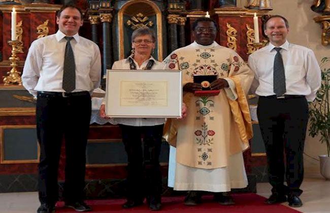 Bischöfliche Auszeichnung (v.l.): Dirigent Raoul Abgottspon, Pfarrer Titus Offor, Jubilarin Bernadette Zurbriggen, Chorpräsident Adrian Furrer