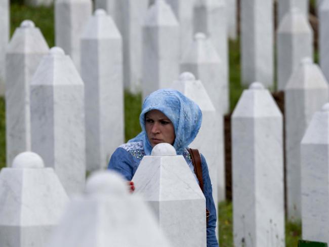 Eine muslimische Frau zwischen Grabsteinen in Srebrenica