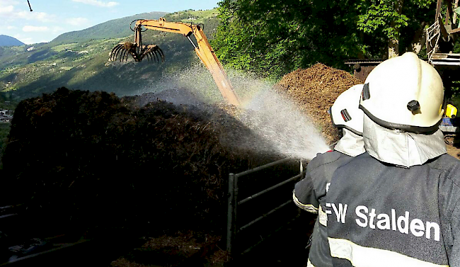 Die Feuerwehrleute löschen die Brandherde mit Wasser.