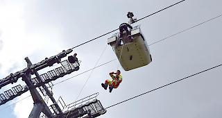 Die Passagiere werden einer nach dem anderen aus den Gondeln abgeseilt.