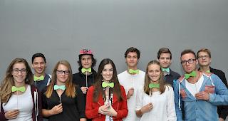 Fliege gemacht. Sch&uuml;ler des Erg&auml;nzungsfach Geschichte mimen den Politologen Claude Longchamp, auch bekannt f&uuml;r seine Kravatten. Hintere Reihe (v.l.) Sebastian Schmid, Beda Johannes Henzen, Lukas Bertholjotti, Xavier Radmann, Matthias Venetz. Vorne (v.l.). Florane Pralong, Lena Maria Seematter, Ilijana Eyer, Kimberly Breuer, Cy-Roberto Schmidt. (Lehrer: Matthias Schmidhalter)