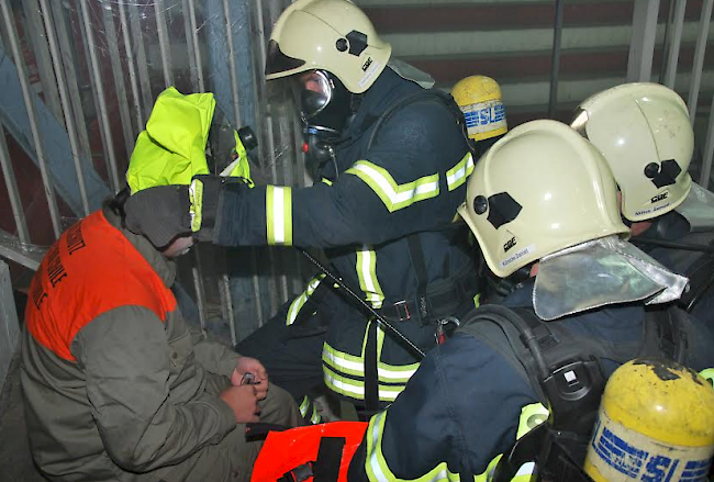 Die Feuerwehr zieht einem Mann, der sich unter Schock nicht mehr selbst bewegen konnte, eine Atemmaske über.