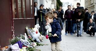 Trauer in Paris: Ein Kind legt Blumen nieder.
