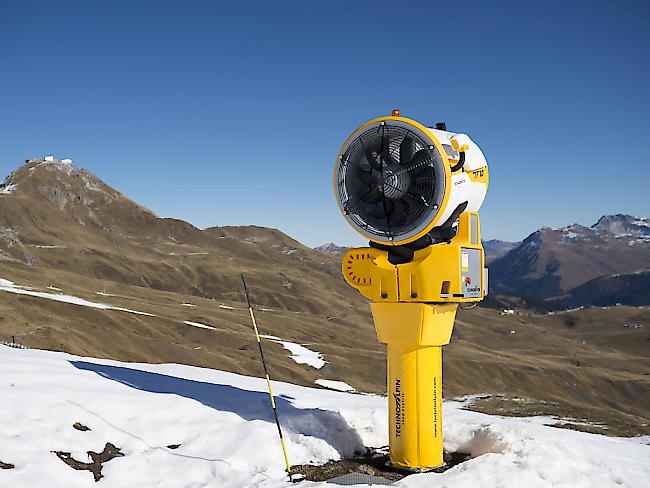 Eine Schneekanone neben einer geöffneten Piste in Arosa. Etwa ein Dutzend Bündner Bergbahnen und Tourismusbetriebe haben wegen des fehlenden Schnees Kurzarbeit angemeldet. (Symbolbild)