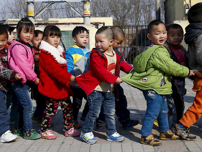 Chinesische Kinder auf dem Schulweg - verheirateten Paaren ist es künftig erlaubt, ein zweites Kind zu bekommen. (Symbolbild)