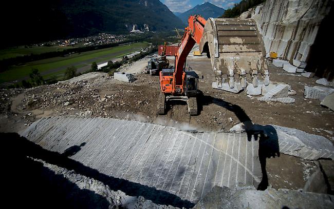Ursprung. Steinmetze arbeiten mit schweren Maschinen am Cresciano-Gneis im Gotthard Steinbruch in Cresciano im Kanton Tessin, wo das Rohmaterial für das Kunstwerk gewonnen wurde. 