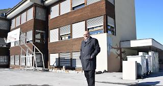 Gemeindepr&auml;sident Christof Biner vor dem sanierungsbed&uuml;rftigen Gr&auml;chner Schulhaus.