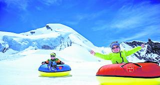 Fr&ouml;hlich. Kinder beim Snowtubing in Saas-Fee. 