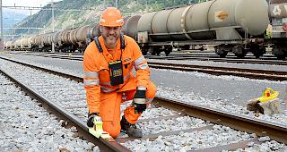 Benjamin Imstepf bringt einen &laquo;Hemmschuh&raquo; auf den Gleisen an, 
um die G&uuml;terwagen abzubremsen.