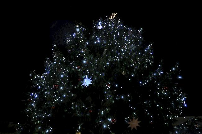 Die Spitze des Weihnachtsbaums, hell erleuchtet und prall behangen.