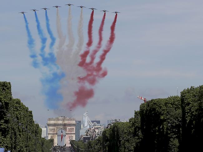 Die traditionelle Militärparade zum Nationalfeiertag hat begonnen: Französische Alphajets der Patrouille de France malen mit farbigem Rauch die französischen Nationalfarben an den Himmel.