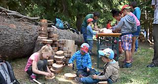 Die Kinder h&auml;mmern N&auml;gel in ein St&uuml;ck Holz um sp&auml;ter mit Faden Muster zu machen.