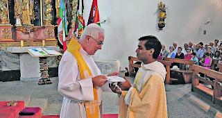 W&uuml;rdevoll. Dekan Anton Carlen (links) setzt Pfarrer Christian Suresh in sein neues Amt ein. 
