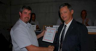 Der Pr&auml;sident des Oberwalliser Feuerwehrverbands Guido Bregy (links) &uuml;berreicht dem langj&auml;hrigen Chef des Kantonalen Amts f&uuml;r Feuerwesen, Eric Senggen, die Urkunde zur Ehrenmitgliedschaft.