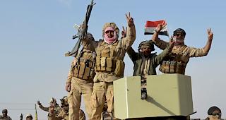 Irakische Einheiten mit Flaggen und Siegeszeichen. Das Land braucht nun Geld zum Wiederaufbau. (Archiv)