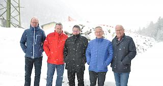 Gemeindepr&auml;sident Konrad Burgener (2. von rechts) informierte &uuml;ber die Bauarbeiten am Schutzdamm (im Hintergrund). Beteiligen wird sich auch die Mobiliar, hier mit Andr&eacute; Heinzmann, Roland L&uuml;thi, J&uuml;rgen Brigger und Thomas Andenmatten (von links).