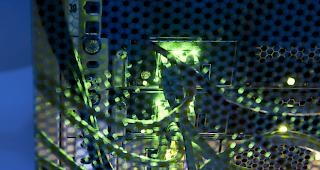 Nahaufnahme eines Server-Racks mit Gittert&uuml;r und Status-LED-L&auml;mpchen in einem gek&uuml;hlten und bel&uuml;fteten Serverraum (Symbolbild).