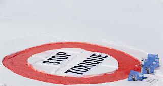 Mitglieder der Alpen-Initiative zeichneten auf dem Simplonpass ein grosses Verbotsschild mit der Aufschrift "Stop Toxique" in den Schnee.