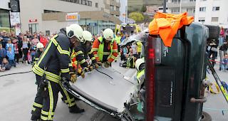 Mit vereinten Kr&auml;ften wird das Dach des &laquo;Unfallautos&raquo; an der Demonstration entfernt.