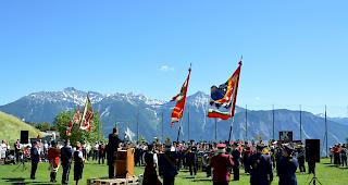 Prachtskulisse. Rudolf Hermann, flankiert von der Fahnendelegation und den Ehrendamen, dirigiert das Gesamtspiel.