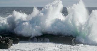 Ein Paar beobachtet die Wassermassen, die an die K&uuml;ste donnern.