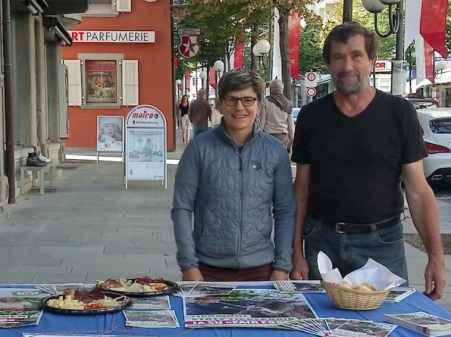 Brigitte Wolf, Präsidentin Grüne Oberwallis, und Eugen Oggenfuss mit einem Infostand vor dem Laden in der Bahnhofstrasse Brig.