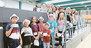 Stolz. Beim Besuch der Druckerei zeigen die Mitglieder des Medienteams ihre Presseausweise.