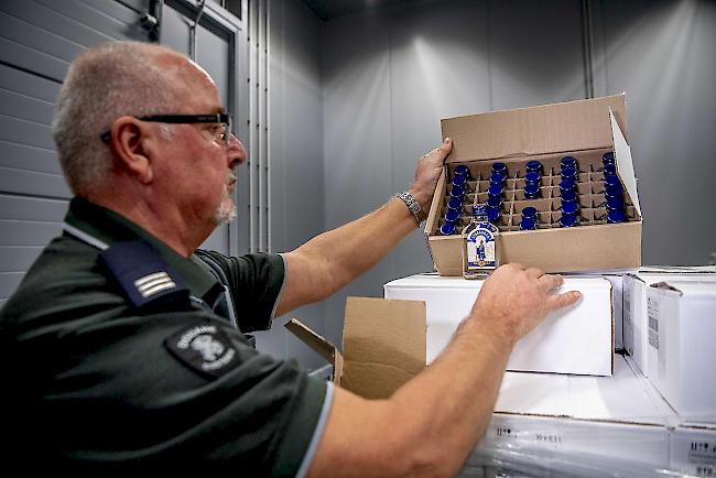 Ein Offizier der Zollbehörden im Hafen von Rotterdam zeigt am 26. Februar 2019 eine Schachtel mit Wodkaflaschen, nachdem ein Container mit 90