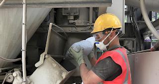 Ein Mitarbeiter von MacRebur f&uuml;llt in der Asphaltaufbereitungsanlage der Ulrich Imboden AG Restplastik ein.