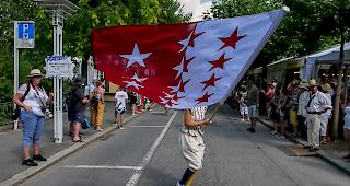 <b>Impressionen.</b> Vom Winde verweht: Der Umzug wurde angef&uuml;hrt von einer Fahnentr&auml;gerin.