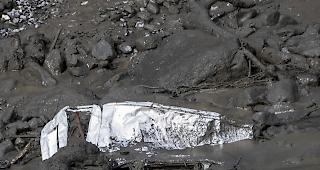 Wrackteile eines am 12. August vom reissenden Strom bef&ouml;rderten Autos im Flussbett der Losentse in Chamoson.