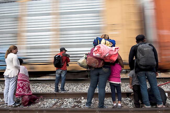 Migrantenfamilien aus Mittelamerika versuchen in den als "The Beast" bekannten Güterzug zu steigen, um die US-Grenze zu erreichen.