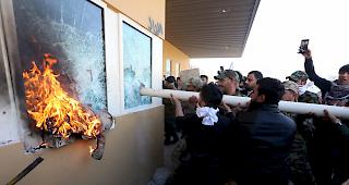 Mitglieder der bewaffneten irakisch-schiitischen "Volksmobilmachungskr&auml;fte" und ihre Anh&auml;nger greifen am 31. Dezember den Eingang der US-Botschaft in Bagdad, Irak an.