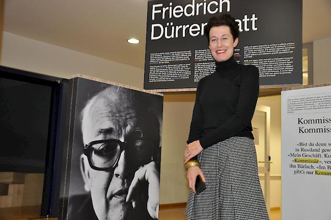 Madeleine Betschart neben einem Porträt Friedrich Dürrenmatts: die Ausstellung Helvetismen lockt noch bis am 1. Februar in die Mediathek Brig.