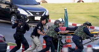 Bewaffnete Kommandosoldaten tragen eine Person aus dem Korat-Einkaufszentrum im Terminal 21 in Nakhon Ratchasima, Thailand.