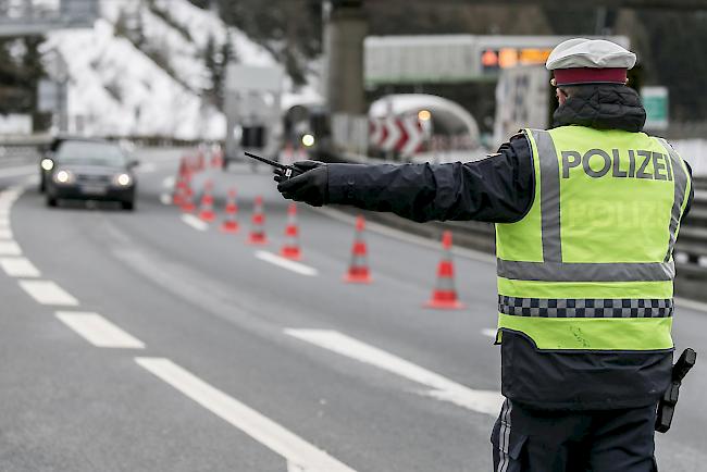 Ein Polizeibeamter leitet am 10. März am Brenner-Grenzübergang zwischen Österreich und Italien ein Auto zur Temperaturkontrolle des Passagiers um.